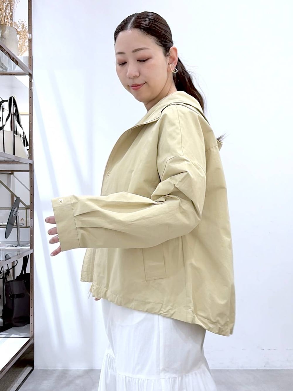 ブラウン系のTシャツ/カットソー、ブラック系のバックパック/リュック、ホワイト系のスカートを着用したレディースの春コーディネートの6枚目の写真