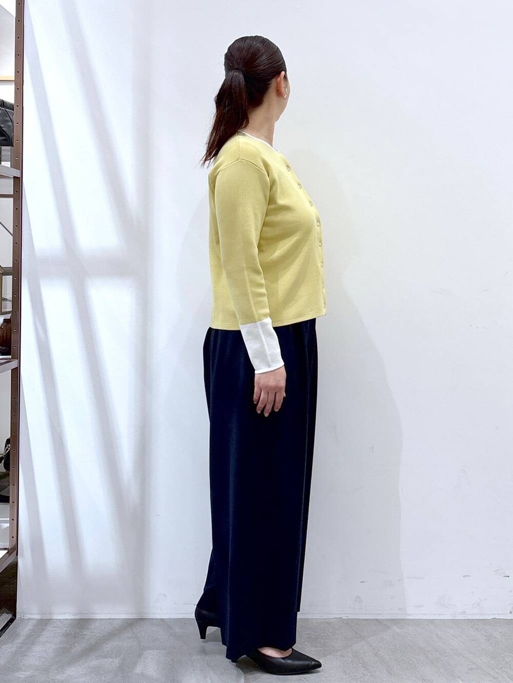 ブラック系のハンドバッグ、ブルー系のその他パンツ、イエロー系のカーディガン/ボレロを着用したレディースの春コーディネートの5枚目の写真