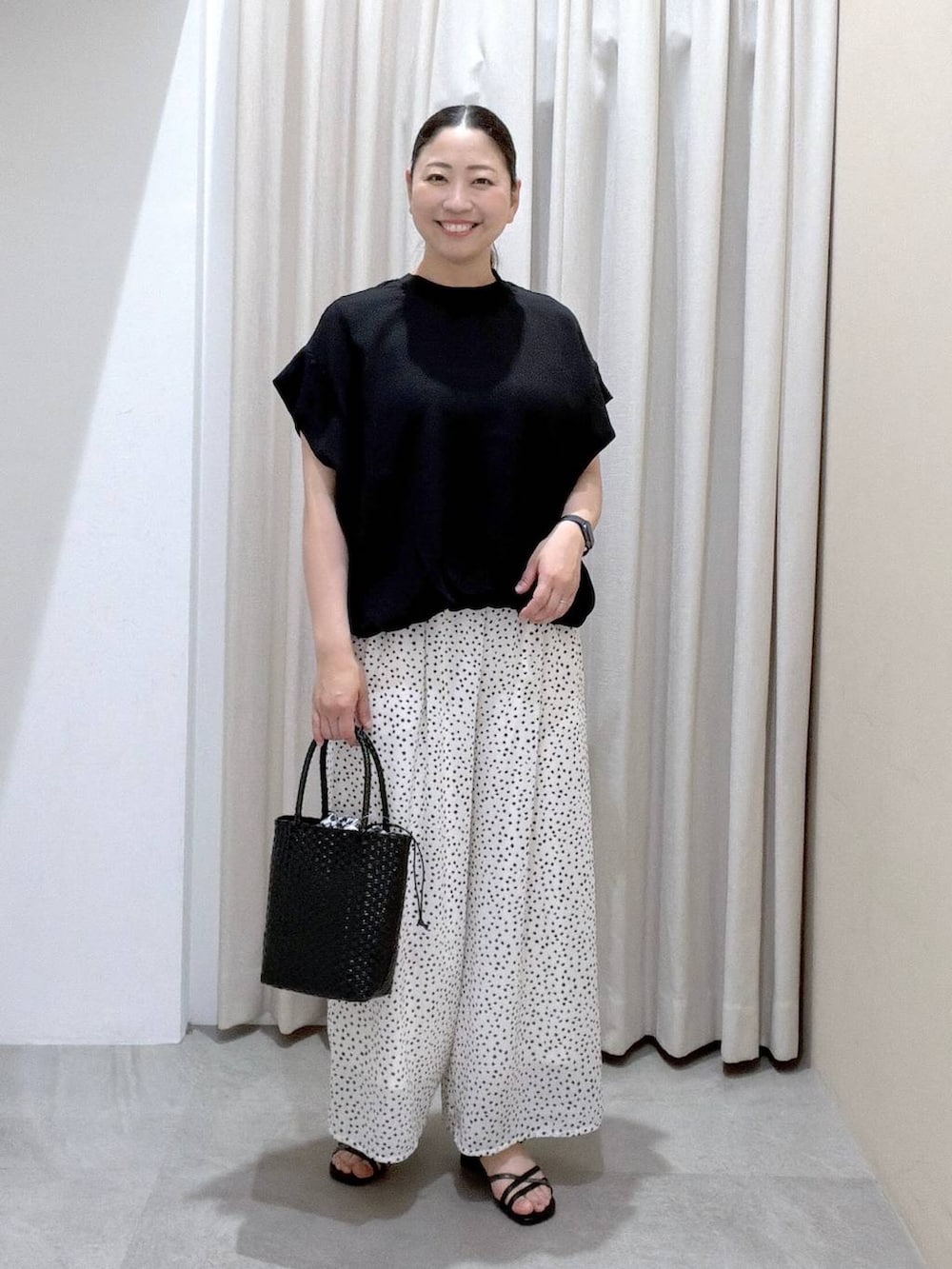 ブラック系のTシャツ/カットソー、ブラック系のサンダル、ホワイト系のその他パンツを着用したレディースの夏コーディネートの2枚目の写真