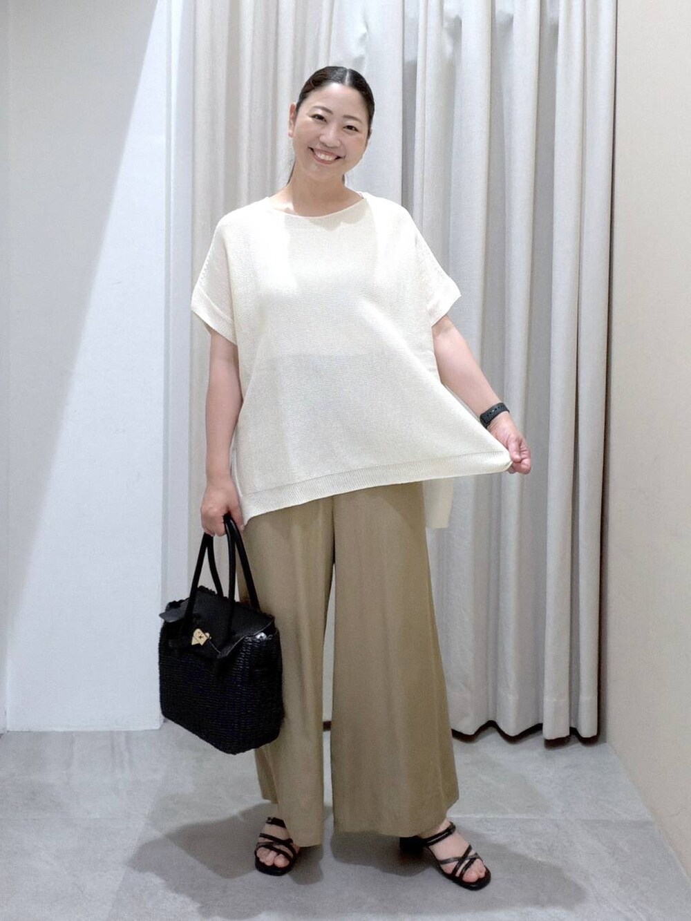 ブラック系のサンダル、ベージュ系のその他パンツ、ブラック系のかごバッグを着用したレディースの夏コーディネートの2枚目の写真