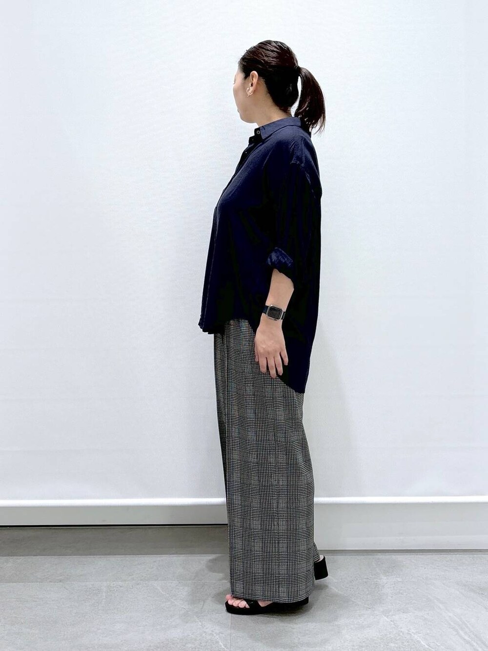 ブラック系のトートバッグ、ブラック系のサンダル、ブルー系のシャツ/ブラウスを着用したレディースの夏コーディネートの3枚目の写真