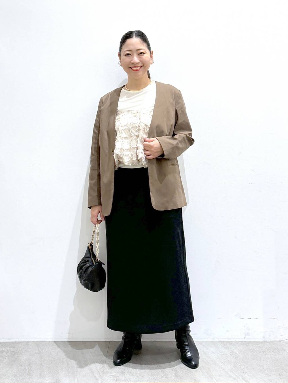 ブラック系のスカート、ブラック系のスカート、ホワイト系のTシャツ/カットソーを着用したレディースの秋コーディネートの2枚目の写真