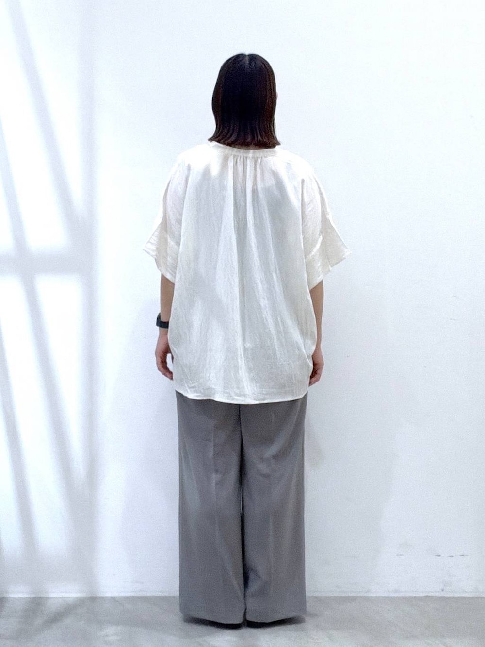 グレー系のその他パンツ、ホワイト系のシャツ/ブラウス、ブラック系のサンダルを着用したレディースの夏コーディネートの4枚目の写真