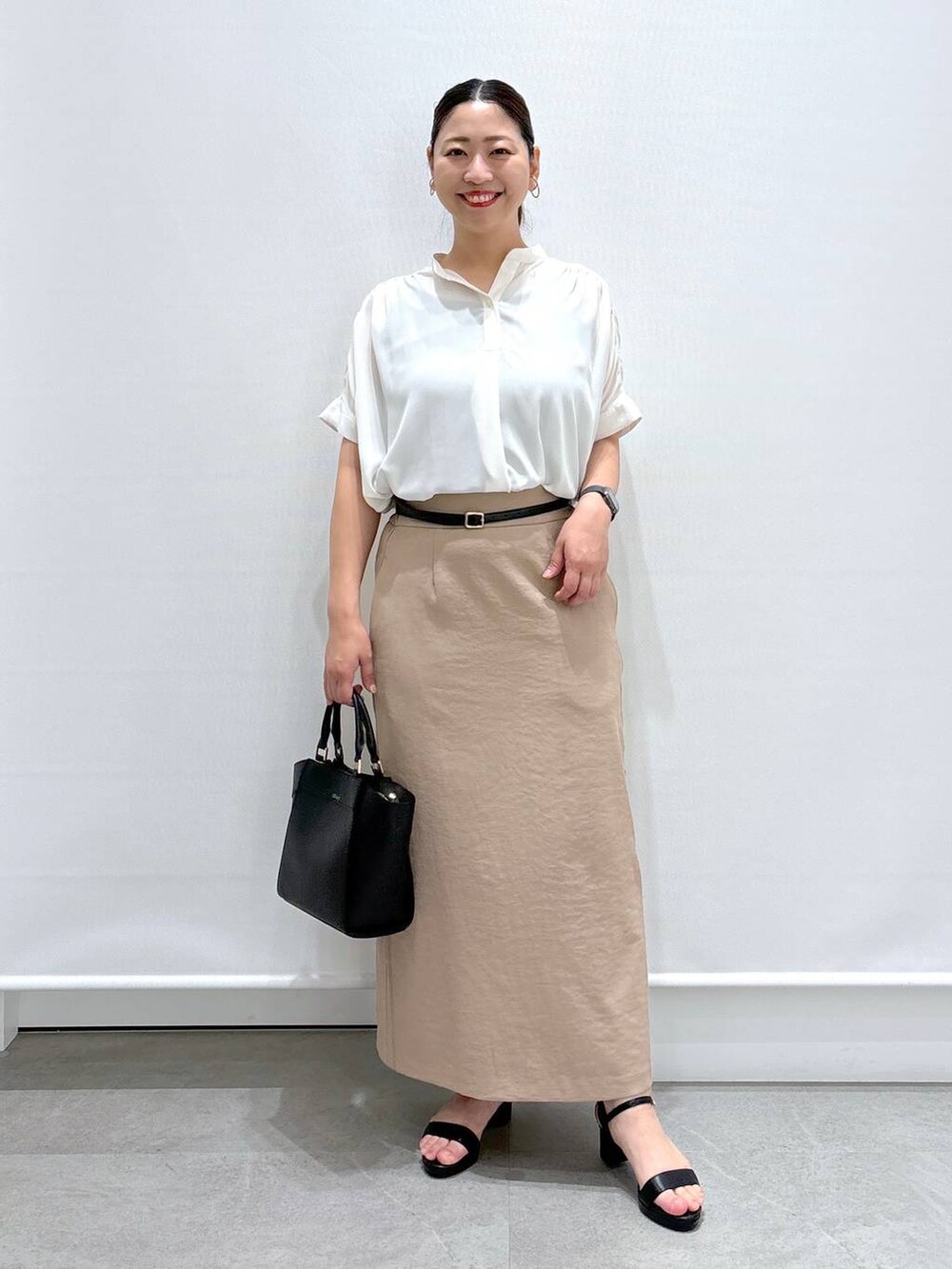 ブラック系のカーディガン/ボレロ、ホワイト系のシャツ/ブラウス、ブラック系のハンドバッグを着用したレディースの夏コーディネートの2枚目の写真