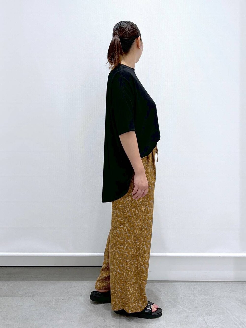 ブラック系のサンダル、ブラック系のTシャツ/カットソー、ブラック系のハンドバッグを着用したレディースの夏コーディネートの5枚目の写真