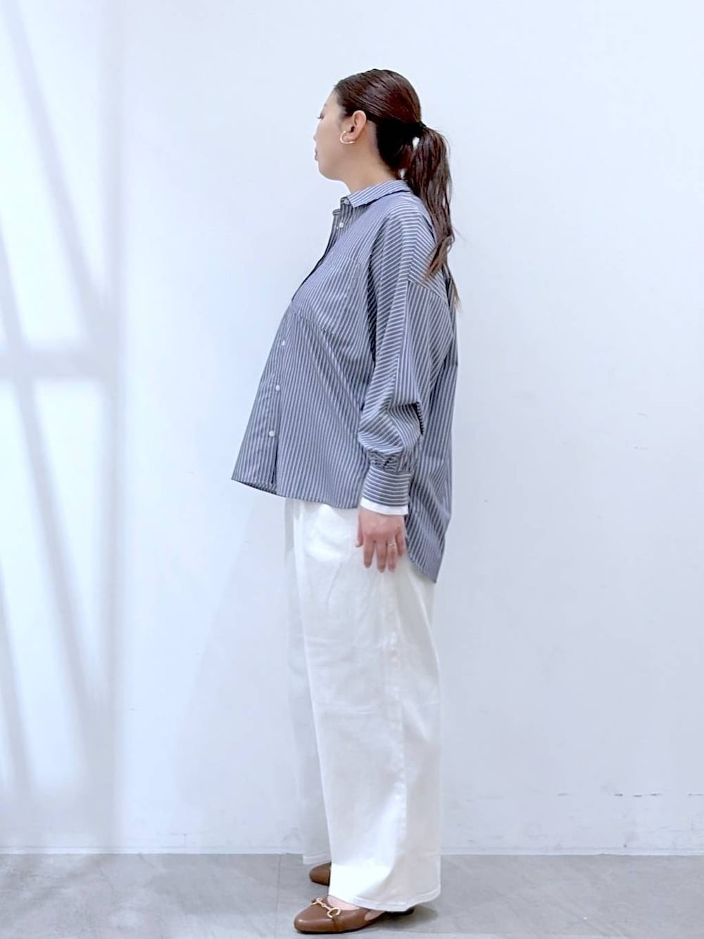 ホワイト系のデニムパンツ、イエロー系のハンドバッグ、ブルー系のシャツ/ブラウスを着用したレディースの春コーディネートの3枚目の写真