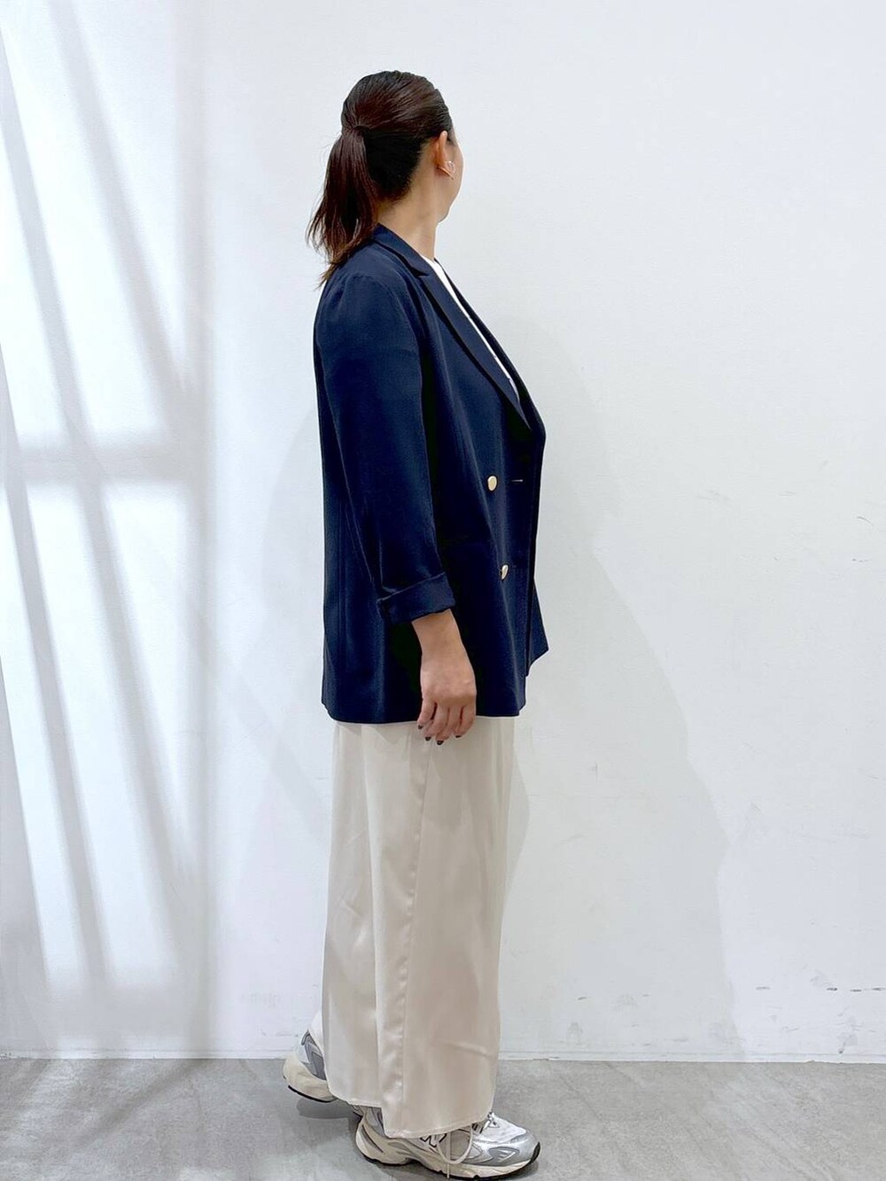 グレー系のスニーカー、シルバー系のトートバッグ、ホワイト系のTシャツ/カットソーを着用したレディースの秋コーディネートの5枚目の写真