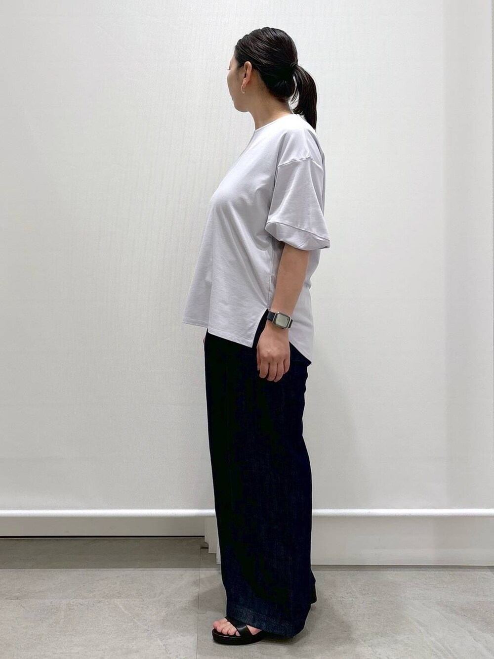 グレー系のTシャツ/カットソー、ブルー系のデニムパンツ、ブラック系のサンダルを着用したレディースの夏コーディネートの3枚目の写真