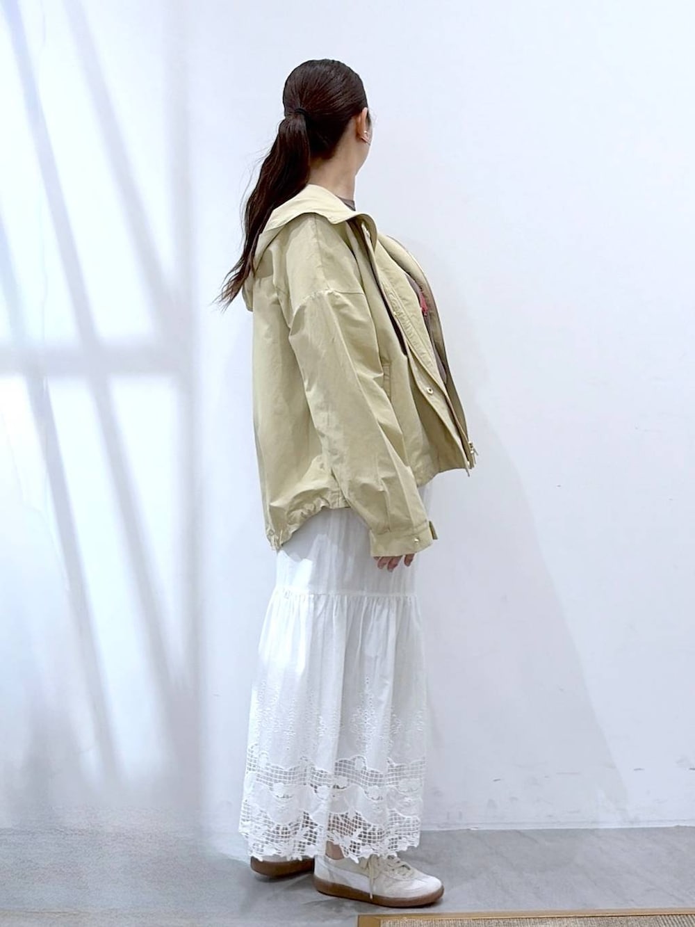 ブラウン系のTシャツ/カットソー、ブラック系のバックパック/リュック、ホワイト系のスカートを着用したレディースの春コーディネートの5枚目の写真