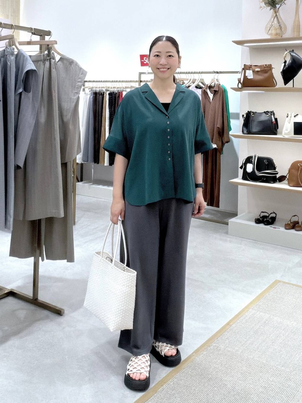 グレー系のその他パンツ、グリーン系のシャツ/ブラウス、ブラック系のタンクトップを着用したレディースの夏コーディネートの2枚目の写真