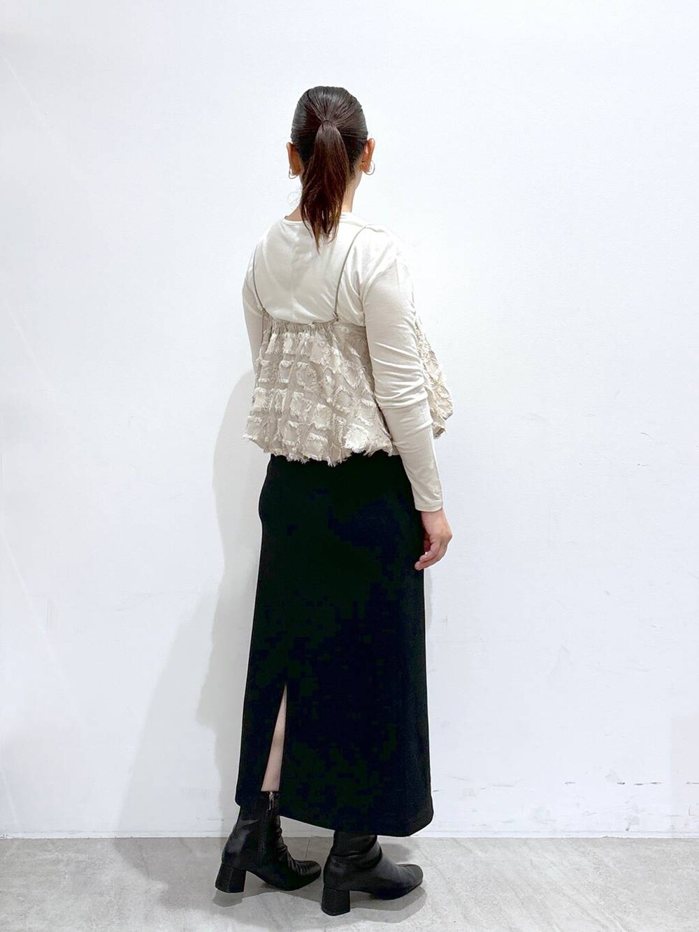 ブラック系のスカート、ブラック系のスカート、ホワイト系のTシャツ/カットソーを着用したレディースの秋コーディネートの4枚目の写真