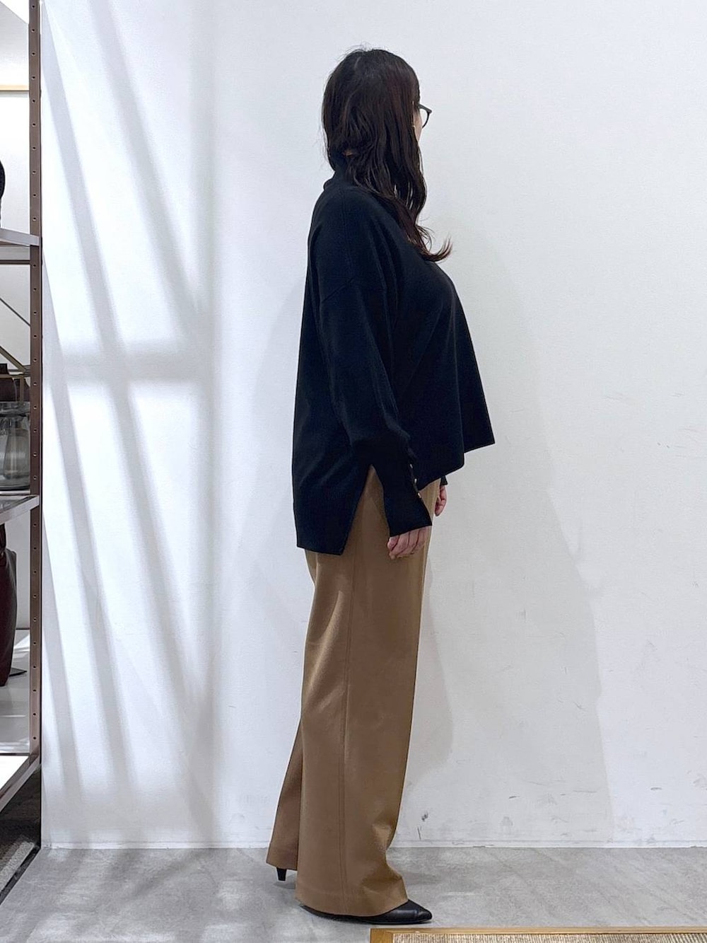 ブラック系のパンプス、ブラック系のニット/セーター、イエロー系のその他パンツを着用したレディースの冬コーディネートの6枚目の写真