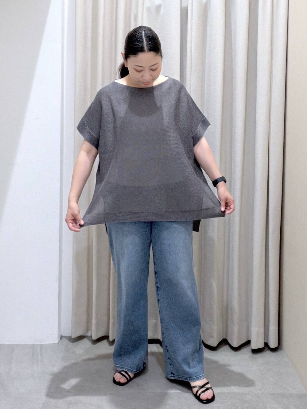 ブラック系のサンダル、ブラック系のかごバッグ、ブルー系のデニムパンツを着用したレディースの夏コーディネートの6枚目の写真