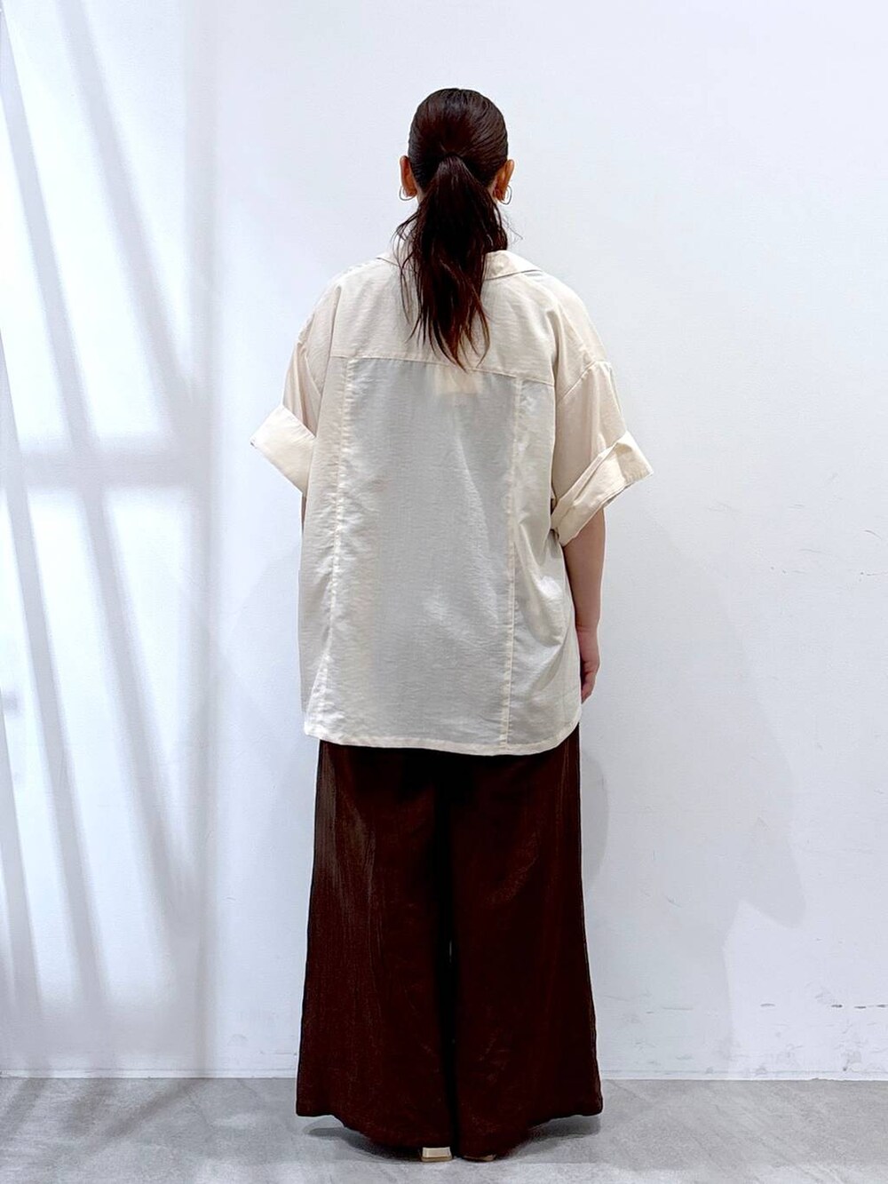 ブラウン系のその他パンツ、ゴールド系のサンダル、ホワイト系のシャツ/ブラウスを着用したレディースの夏コーディネートの4枚目の写真