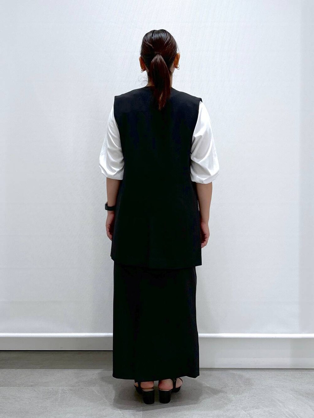 ブラック系のトートバッグ、ブラック系のサンダル、ブラック系のスカートを着用したレディースの秋コーディネートの4枚目の写真