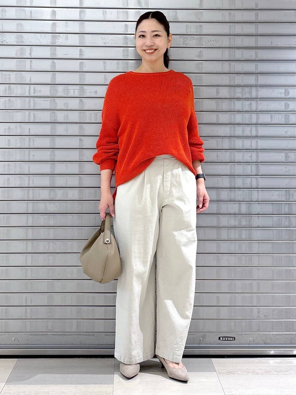 ベージュ系のパンプス、オレンジ系のニット/セーター、ベージュ系のその他パンツを着用したレディースの春コーディネートの2枚目の写真