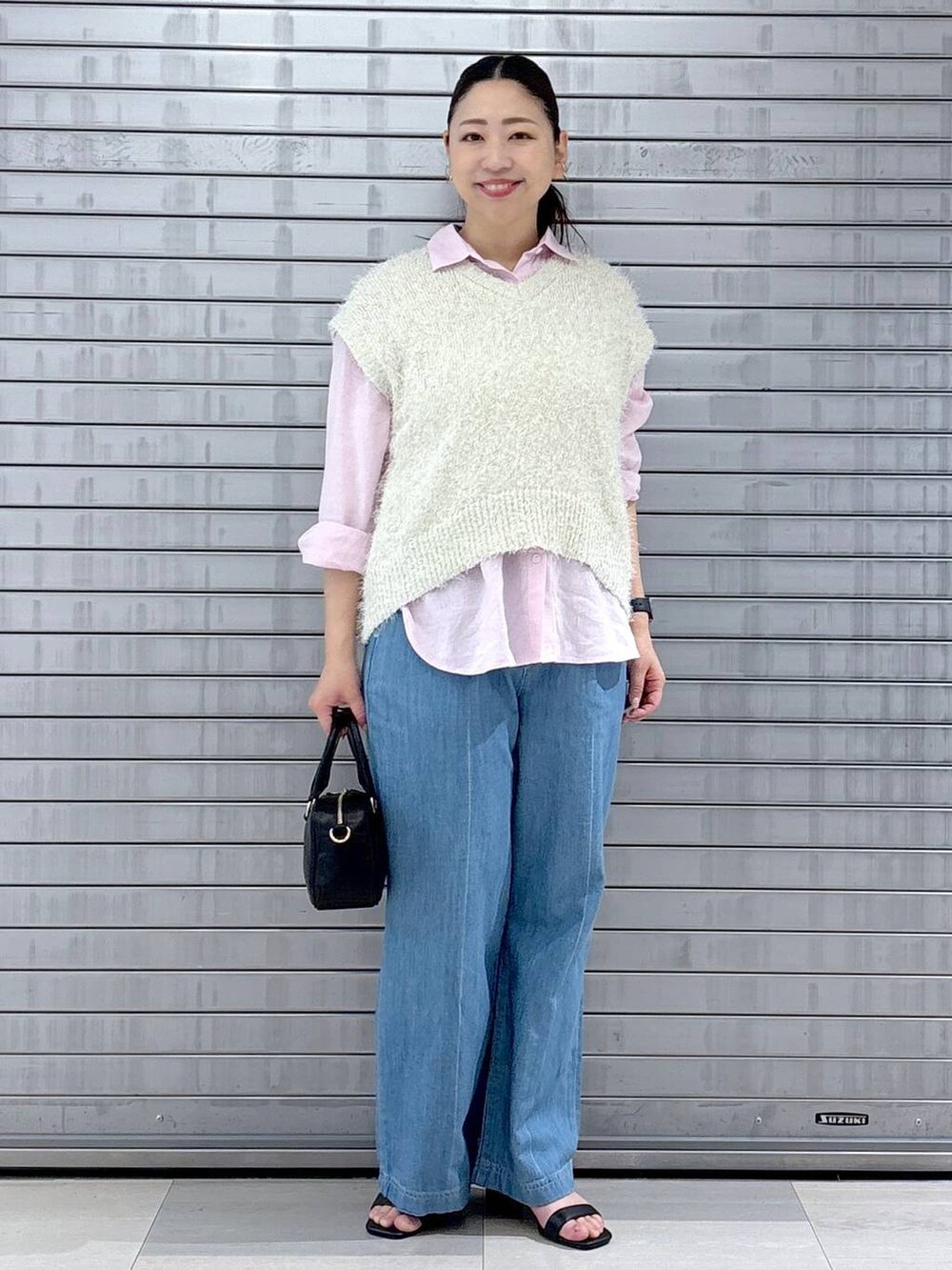 ピンク系のシャツ/ブラウス、ホワイト系のベスト、ブラック系のハンドバッグを着用したレディースの春コーディネートの2枚目の写真