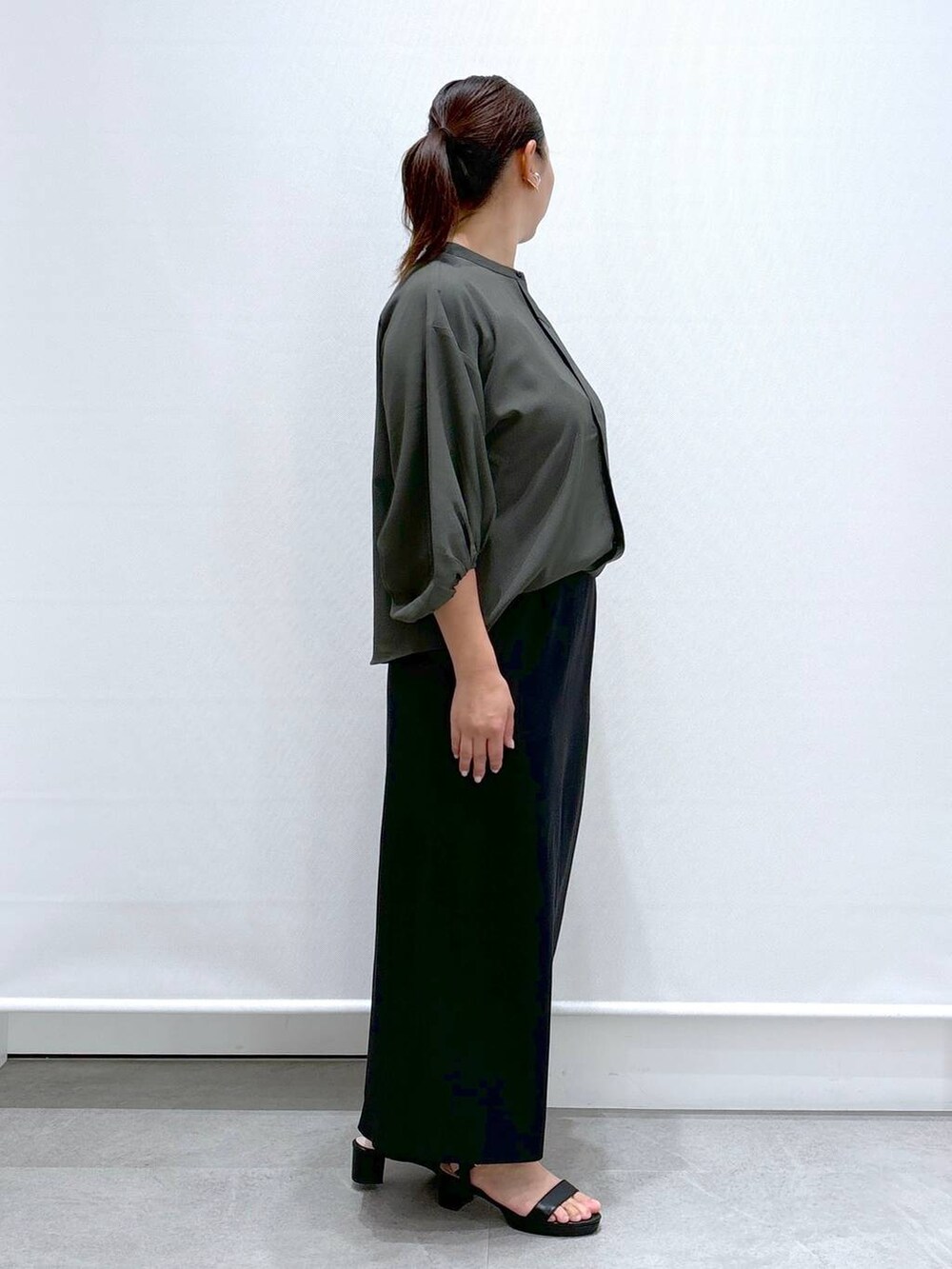 グリーン系のシャツ/ブラウス、ブラック系のサンダル、ブラック系のスカートを着用したレディースの秋コーディネートの4枚目の写真