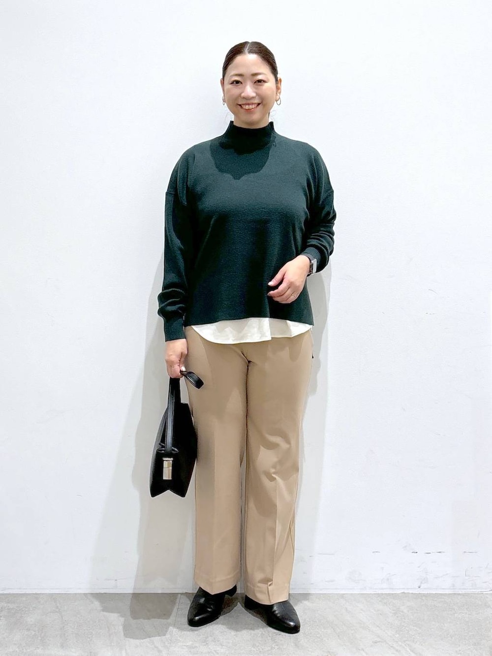 ホワイト系のシャツ/ブラウス、ブラック系のブーツ、グリーン系のニット/セーターを着用したレディースの秋コーディネートの2枚目の写真