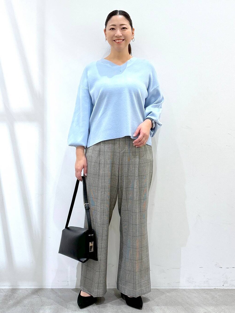 グレー系のその他パンツ、ブラック系のその他パンツ、ブルー系のニット/セーターを着用したレディースの冬コーディネートの2枚目の写真