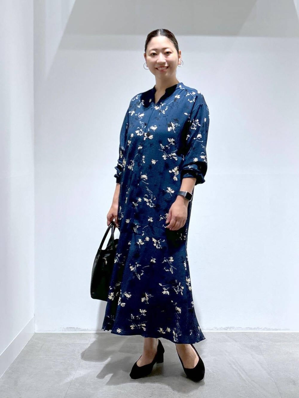 ブラック系のハンドバッグ、ブラック系のパンプスを着用したレディースの秋コーディネートの2枚目の写真