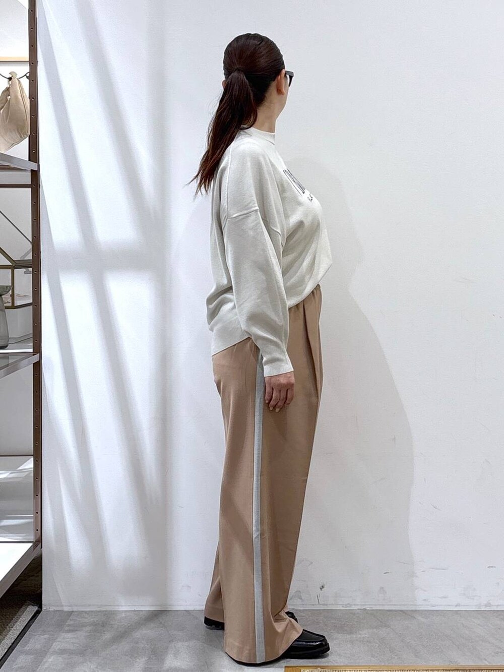 ベージュ系のTシャツ/カットソー、ブラック系のハンドバッグ、ブルー系のテーラードジャケットを着用したレディースの秋コーディネートの4枚目の写真