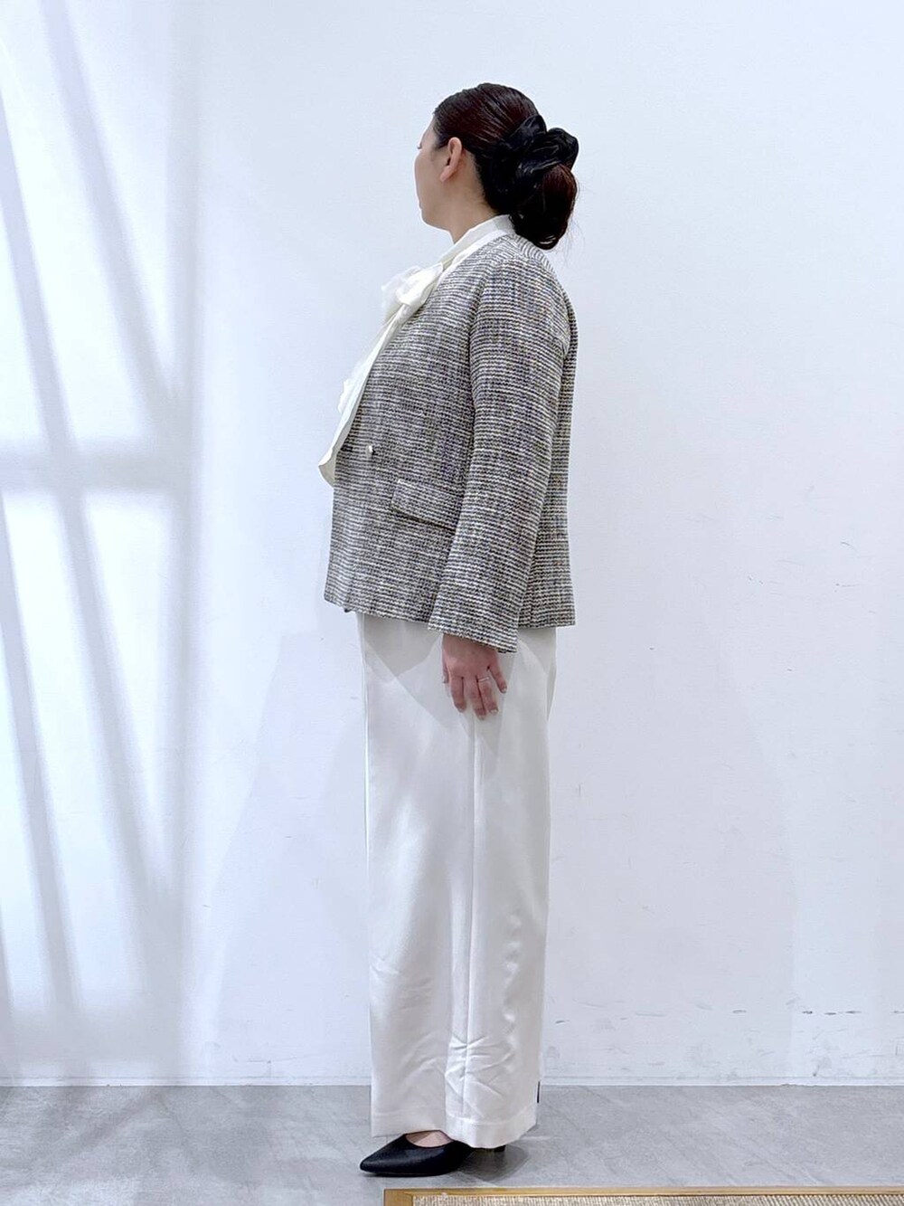 ブラック系のハンドバッグ、ブラック系のノーカラージャケット、ホワイト系のシャツ/ブラウスを着用したレディースの冬コーディネートの3枚目の写真