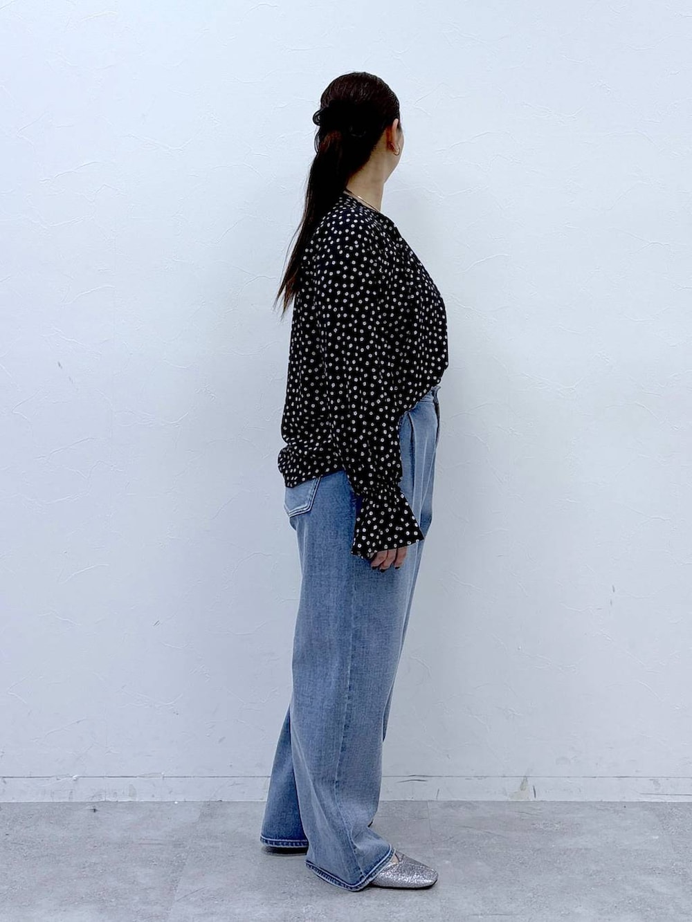 ブラック系のハンドバッグ、ブルー系のデニムパンツ、ブラック系のシャツ/ブラウスを着用したレディースの春コーディネートの5枚目の写真