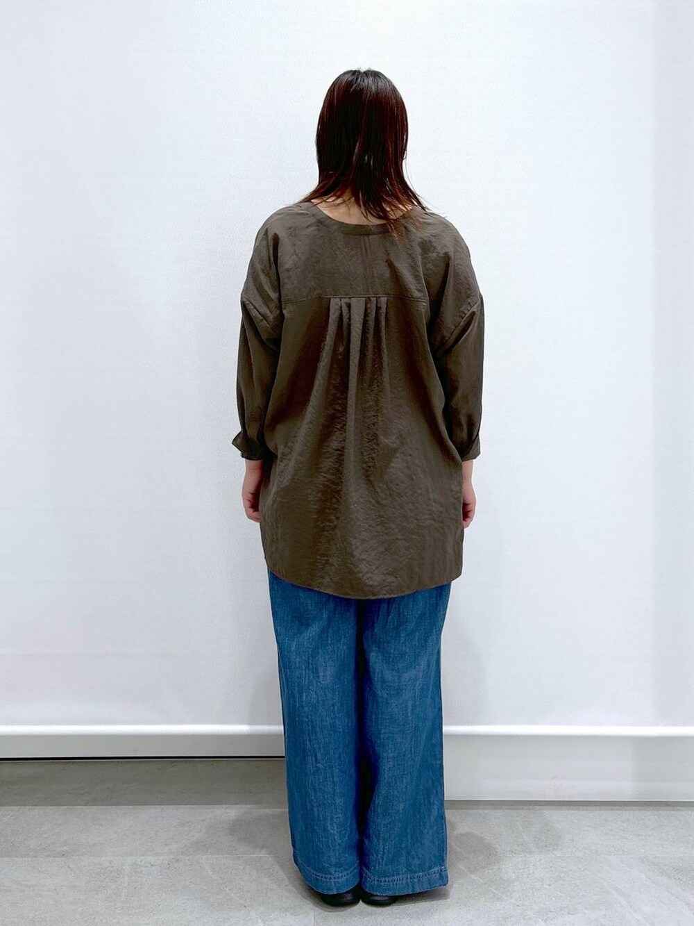 ブルー系のデニムパンツ、ブラック系のサンダル、ブラック系のハンドバッグを着用したレディースの夏コーディネートの4枚目の写真