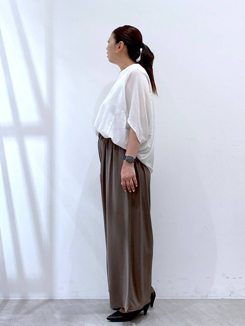 ブラック系のパンプス、ホワイト系のTシャツ/カットソー、ブラック系のハンドバッグを着用したレディースの夏コーディネートの3枚目の写真