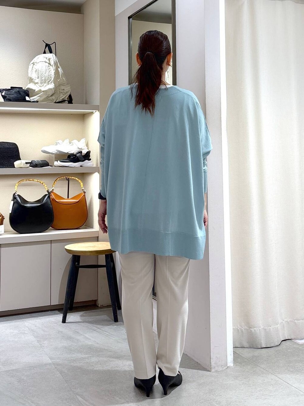 ブラック系のパンプス、ホワイト系のTシャツ/カットソー、ブラック系のハンドバッグを着用したレディースの夏コーディネートの4枚目の写真