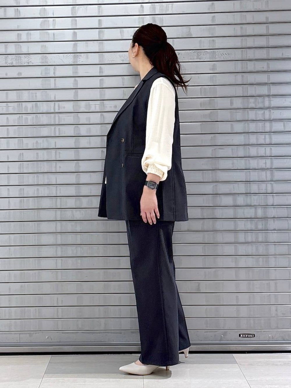 ホワイト系のハンドバッグ、グレー系のベスト、ホワイト系のシャツ/ブラウスを着用したレディースの春コーディネートの3枚目の写真