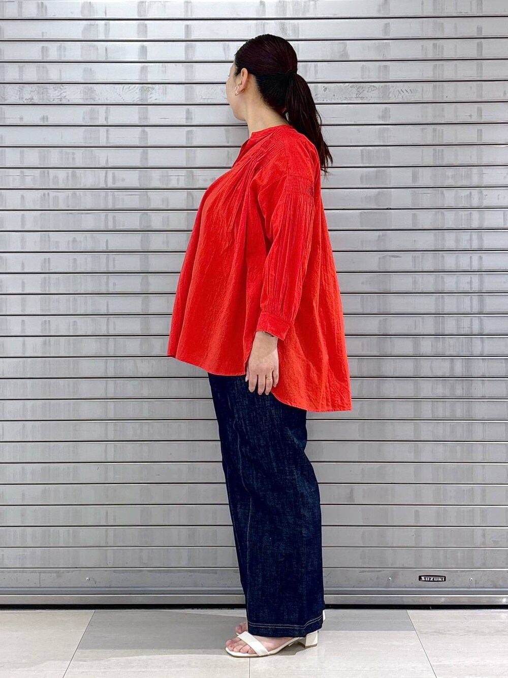 レッド系のシャツ/ブラウス、グレー系のその他パンツ、ホワイト系のハンドバッグを着用したレディースの春コーディネートの3枚目の写真