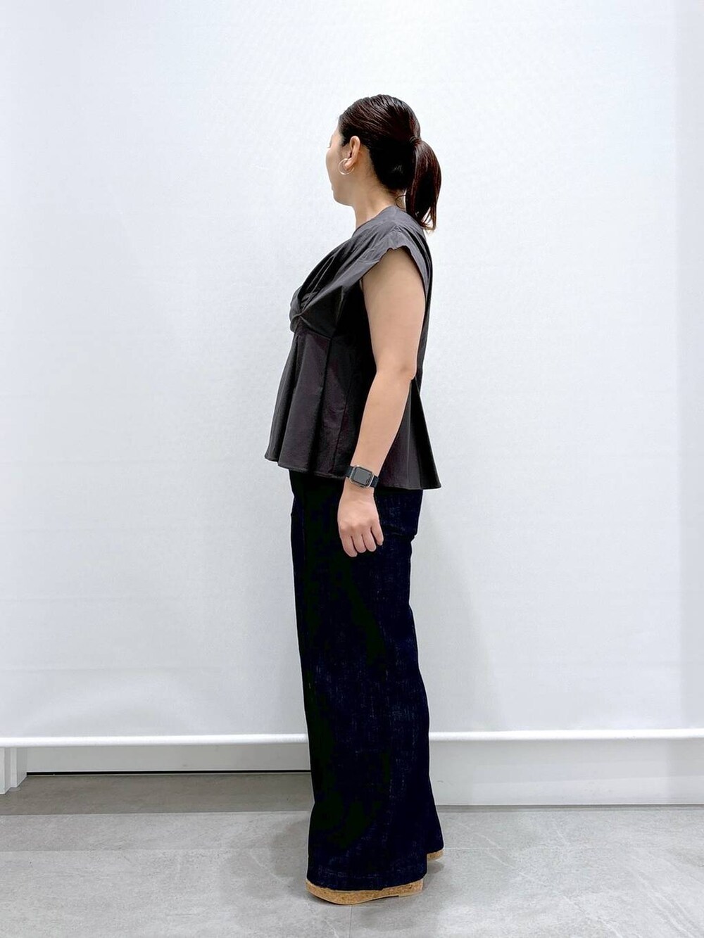 ブルー系のデニムパンツ、ベージュ系のサンダル、グレー系のシャツ/ブラウスを着用したレディースの夏コーディネートの3枚目の写真