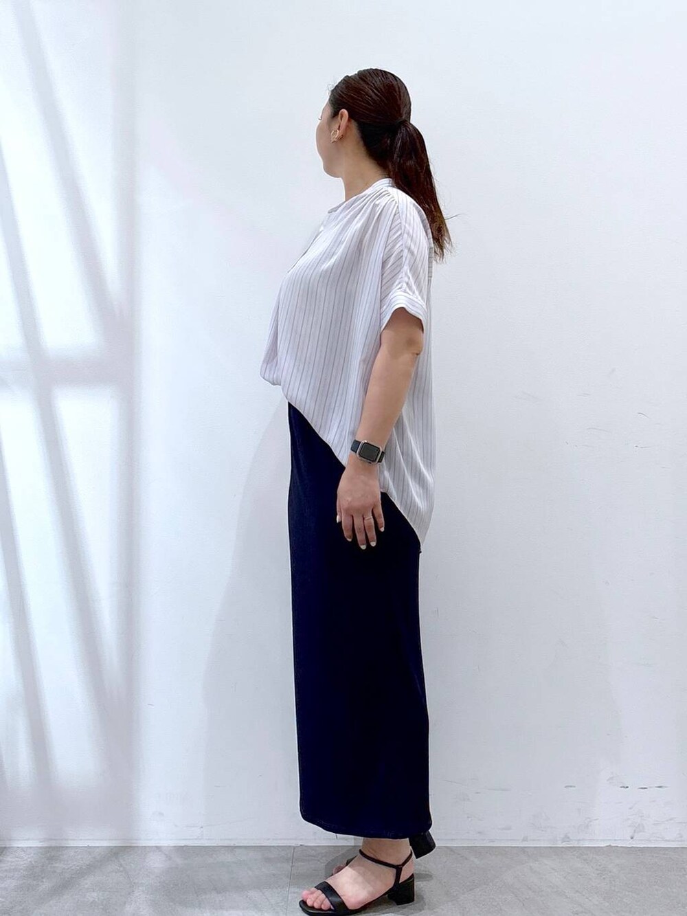 ブルー系のスカート、ブラック系のハンドバッグ、ブルー系のシャツ/ブラウスを着用したレディースの夏コーディネートの3枚目の写真