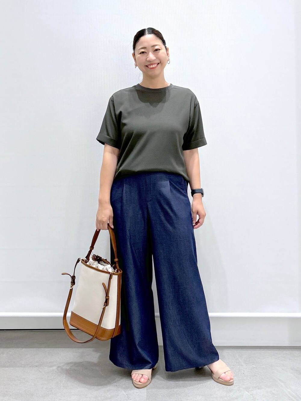 ブルー系のデニムパンツ、ベージュ系のサンダル、ブルー系のデニムパンツを着用したレディースの夏コーディネートの2枚目の写真