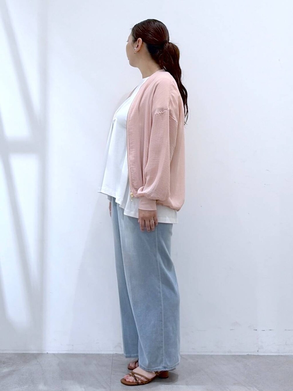 ブラウン系のサンダル、ホワイト系のTシャツ/カットソー、ブルー系のデニムパンツを着用したレディースの夏コーディネートの3枚目の写真