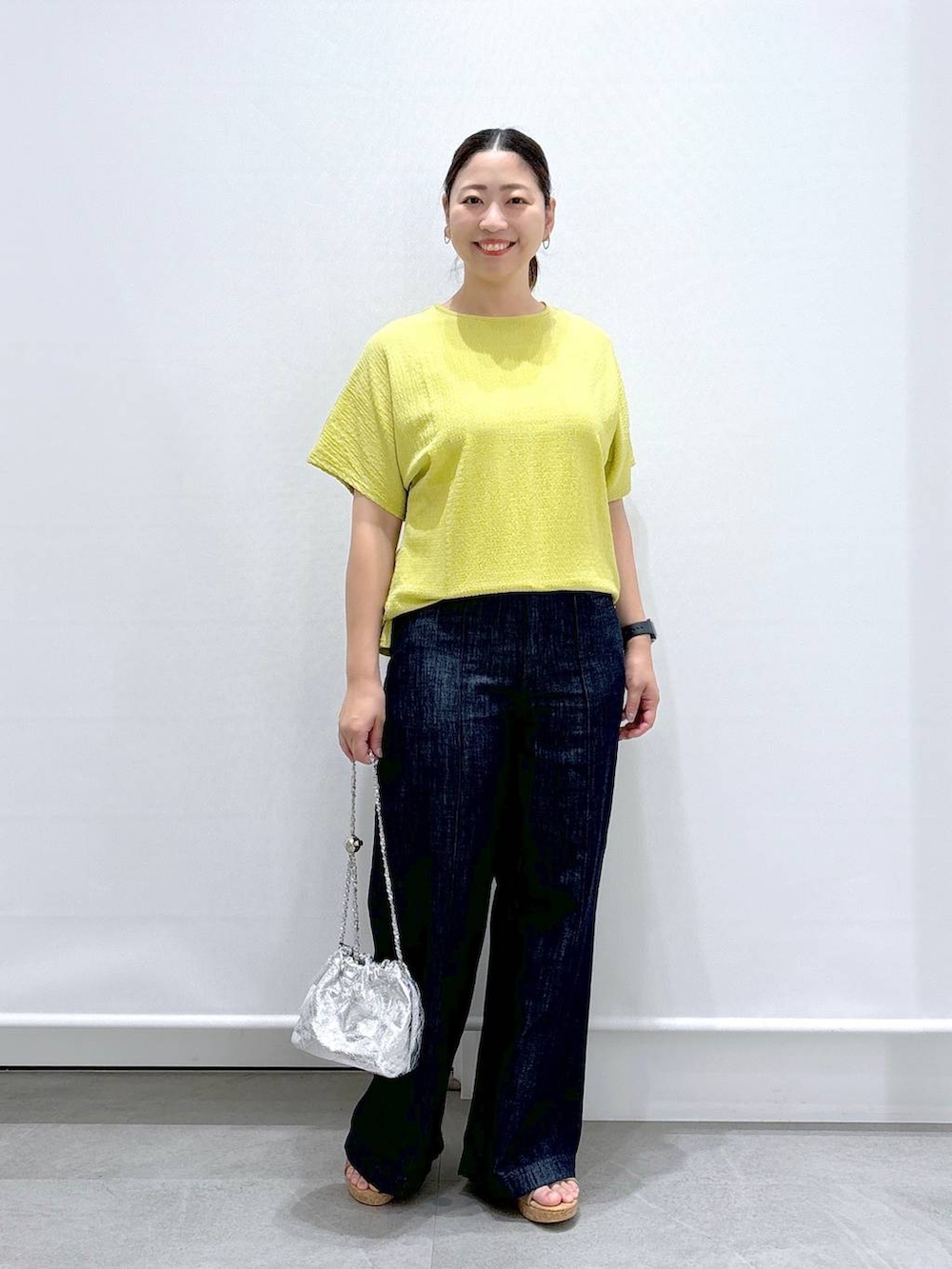 ブルー系のデニムパンツ、ベージュ系のサンダル、イエロー系のTシャツ/カットソーを着用したレディースの夏コーディネートの2枚目の写真