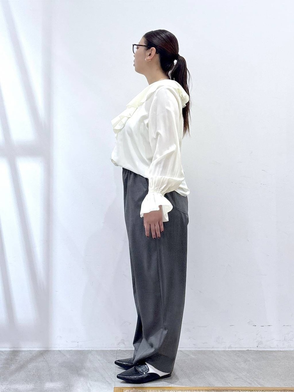 ブラック系のパンプス、ブルー系のカーディガン/ボレロ、ブラック系のハンドバッグを着用したレディースの冬コーディネートの4枚目の写真