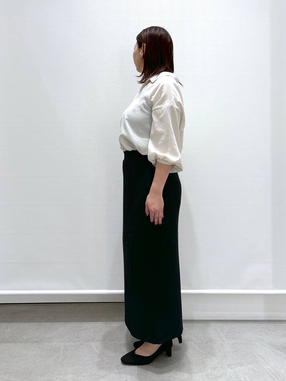 ホワイト系のTシャツ/カットソー、ブラック系のハンドバッグ、ブラック系のパンプスを着用したレディースの春コーディネートの3枚目の写真