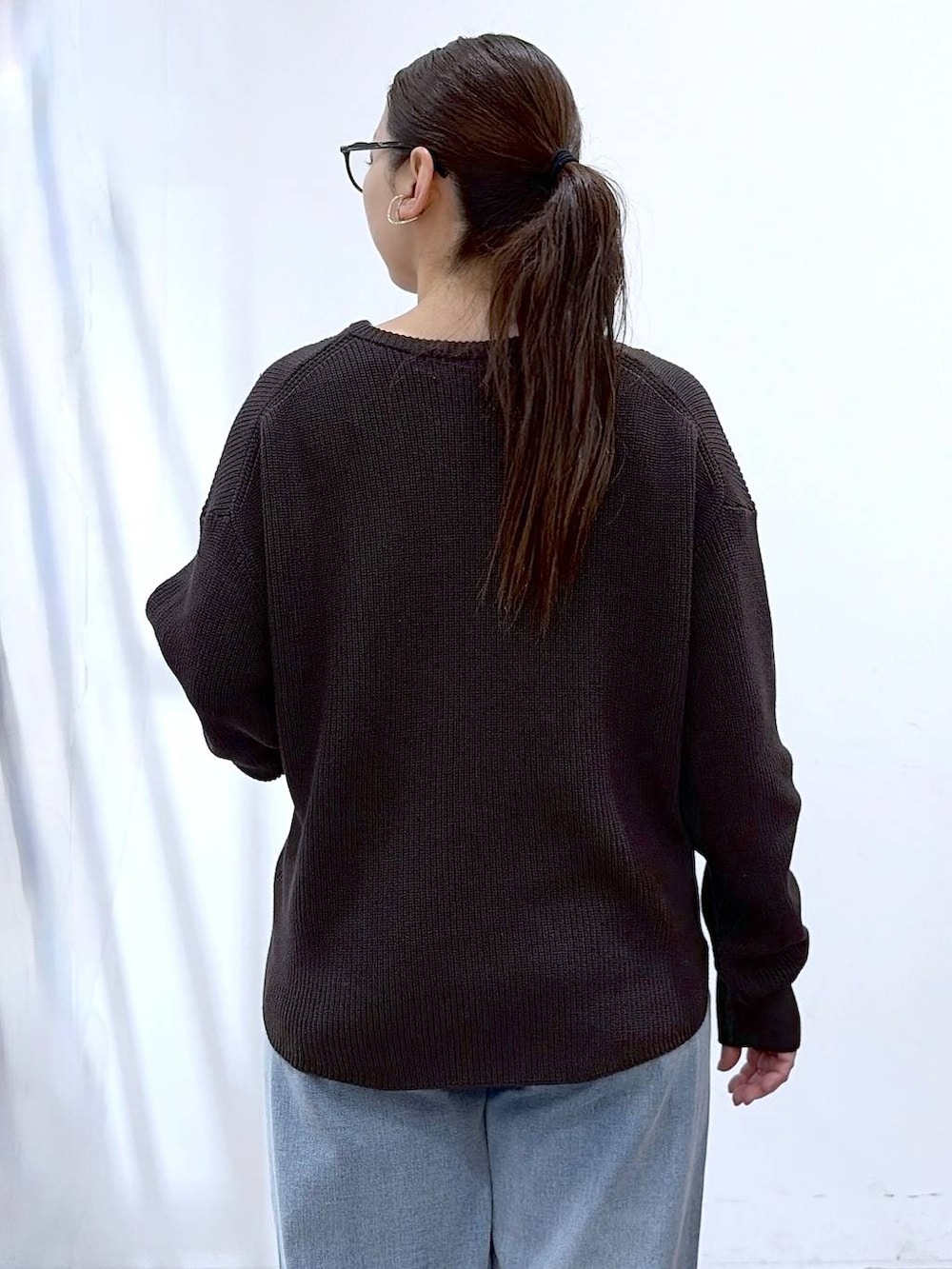 ホワイト系のタンクトップ、ブルー系のデニムパンツ、ブラック系のパンプスを着用したレディースの春コーディネートの8枚目の写真