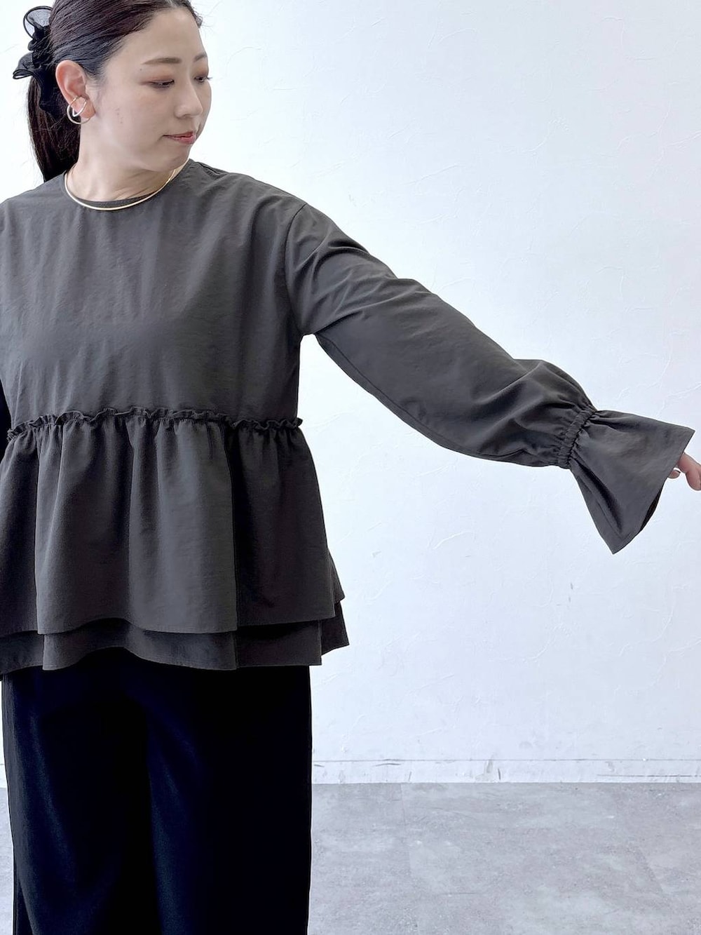 ブラック系のトートバッグ、ブラック系のパンプス、ブラウン系のシャツ/ブラウスを着用したレディースの冬コーディネートの6枚目の写真