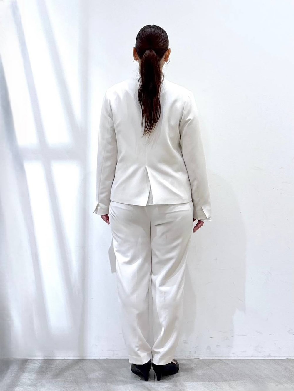 ブラック系のハンドバッグ、ホワイト系のシャツ/ブラウス、ホワイト系のノーカラージャケットを着用したレディースの春コーディネートの4枚目の写真