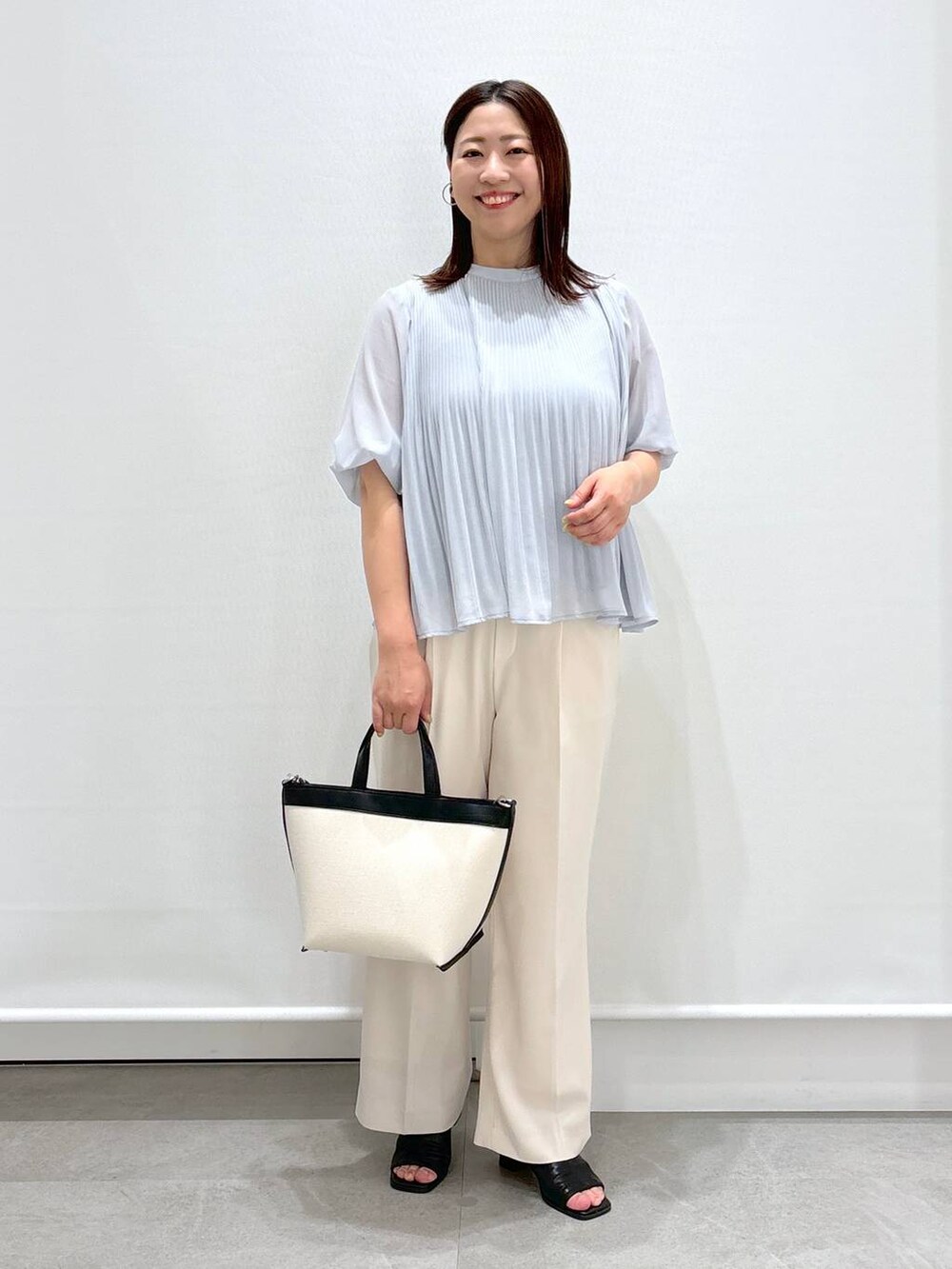 ホワイト系のその他パンツ、ブラック系のサンダル、ブルー系のシャツ/ブラウスを着用したレディースの春コーディネートの2枚目の写真