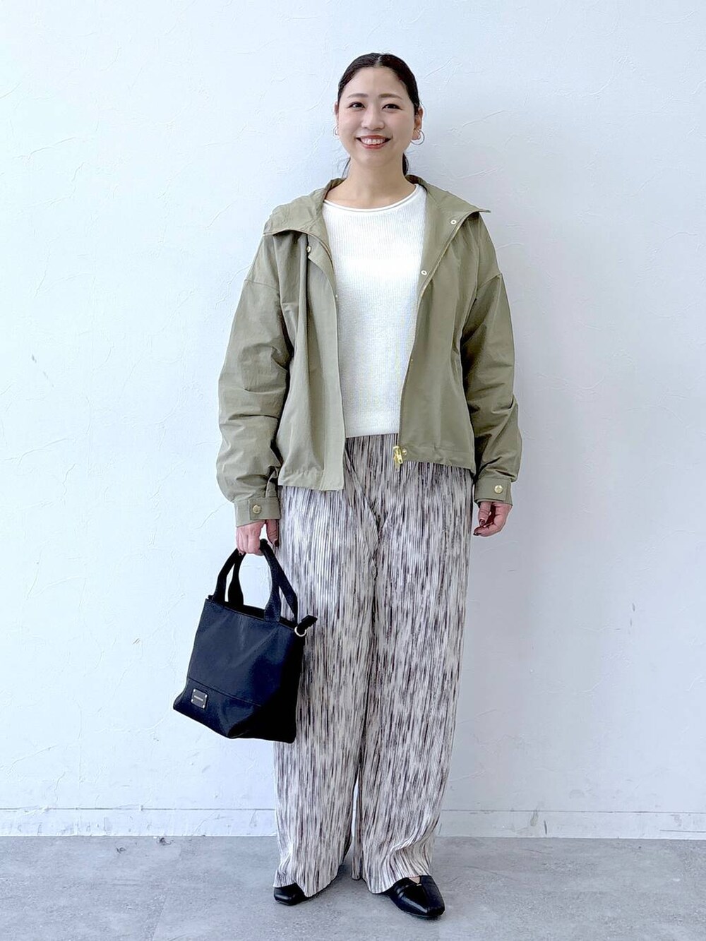 ブラック系のトートバッグ、ブラック系のパンプス、ホワイト系のその他パンツを着用したレディースの冬コーディネートの2枚目の写真