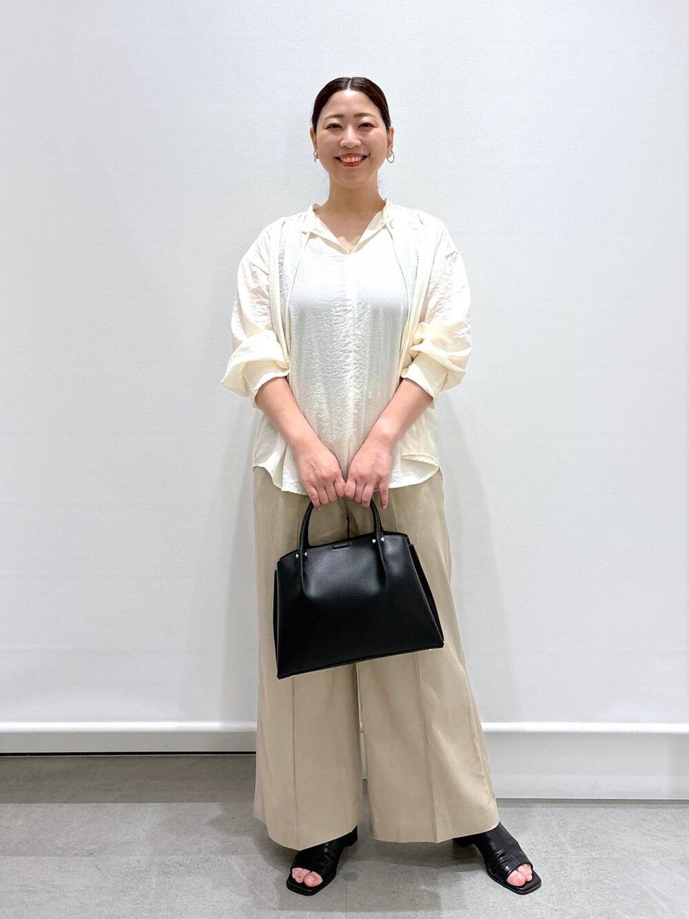 ベージュ系のその他パンツ、ブラック系のショルダーバッグ、ホワイト系のシャツ/ブラウスを着用したレディースの春コーディネートの2枚目の写真