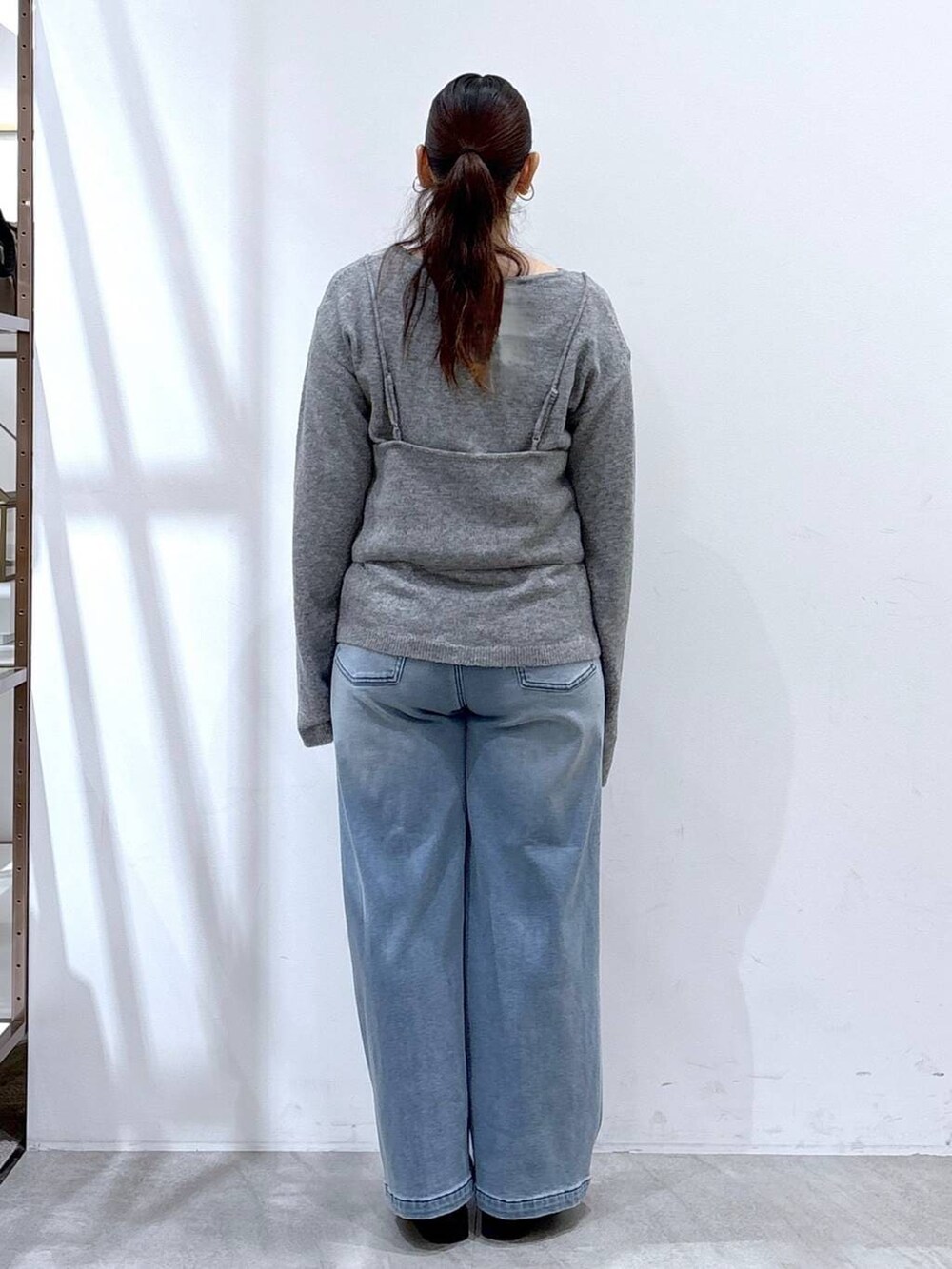 ブラック系のブーツ、ブルー系のデニムパンツ、グレー系のニット/セーターを着用したレディースの冬コーディネートの4枚目の写真