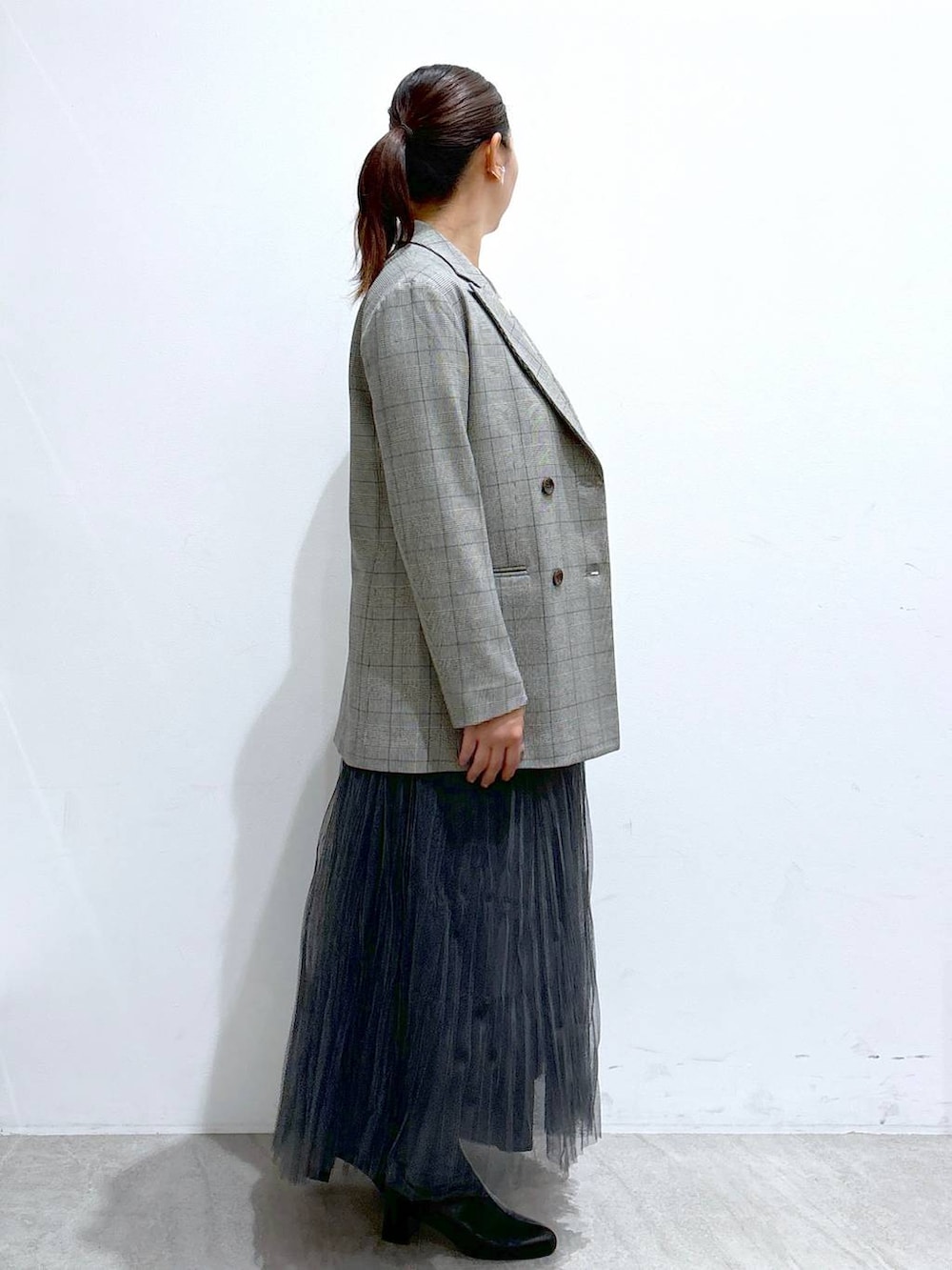 ブラック系のその他アウター、ブラック系のハンドバッグ、グレー系のスカートを着用したレディースの秋コーディネートの5枚目の写真