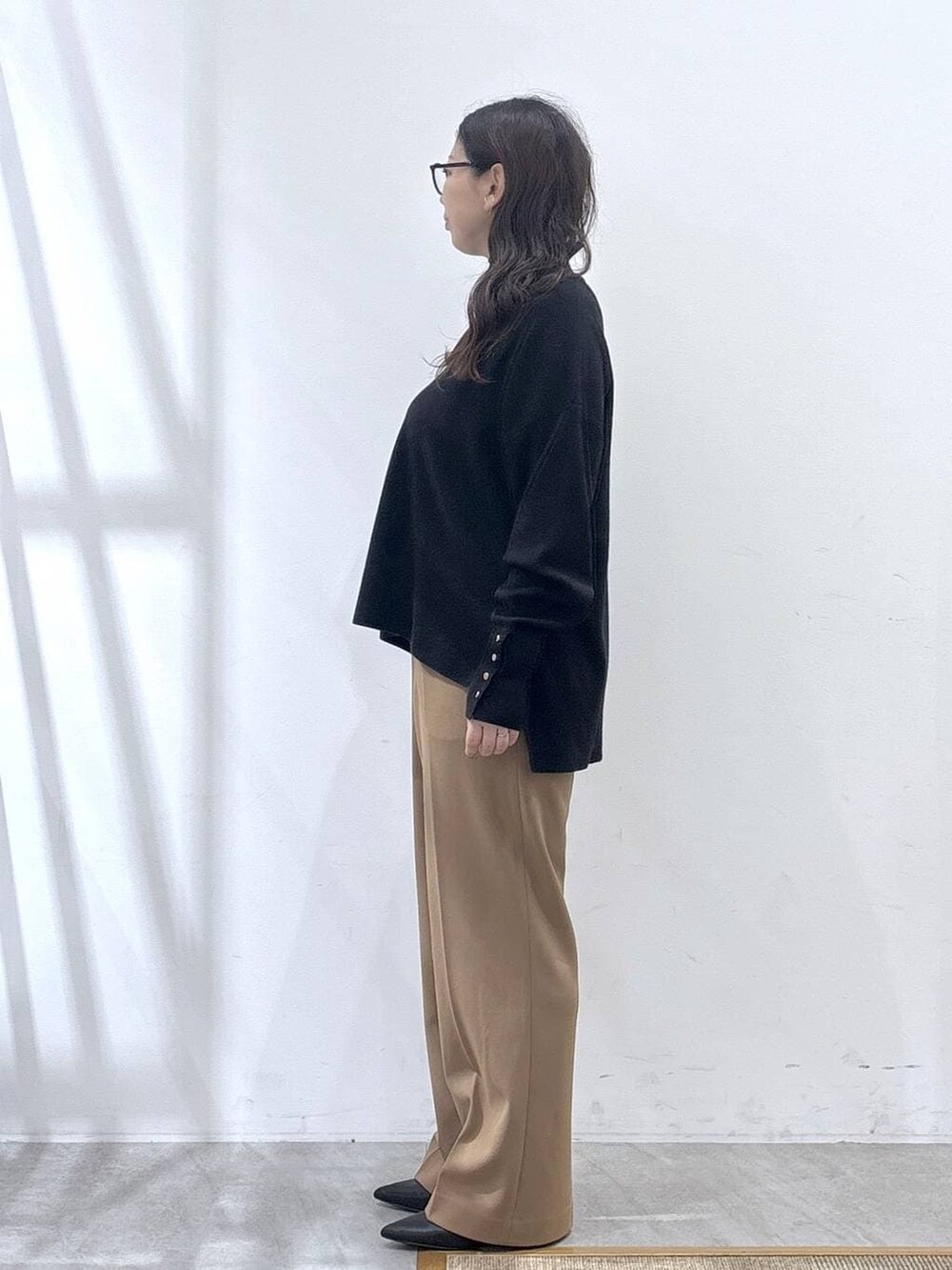 ブラック系のパンプス、ブラック系のニット/セーター、イエロー系のその他パンツを着用したレディースの冬コーディネートの3枚目の写真