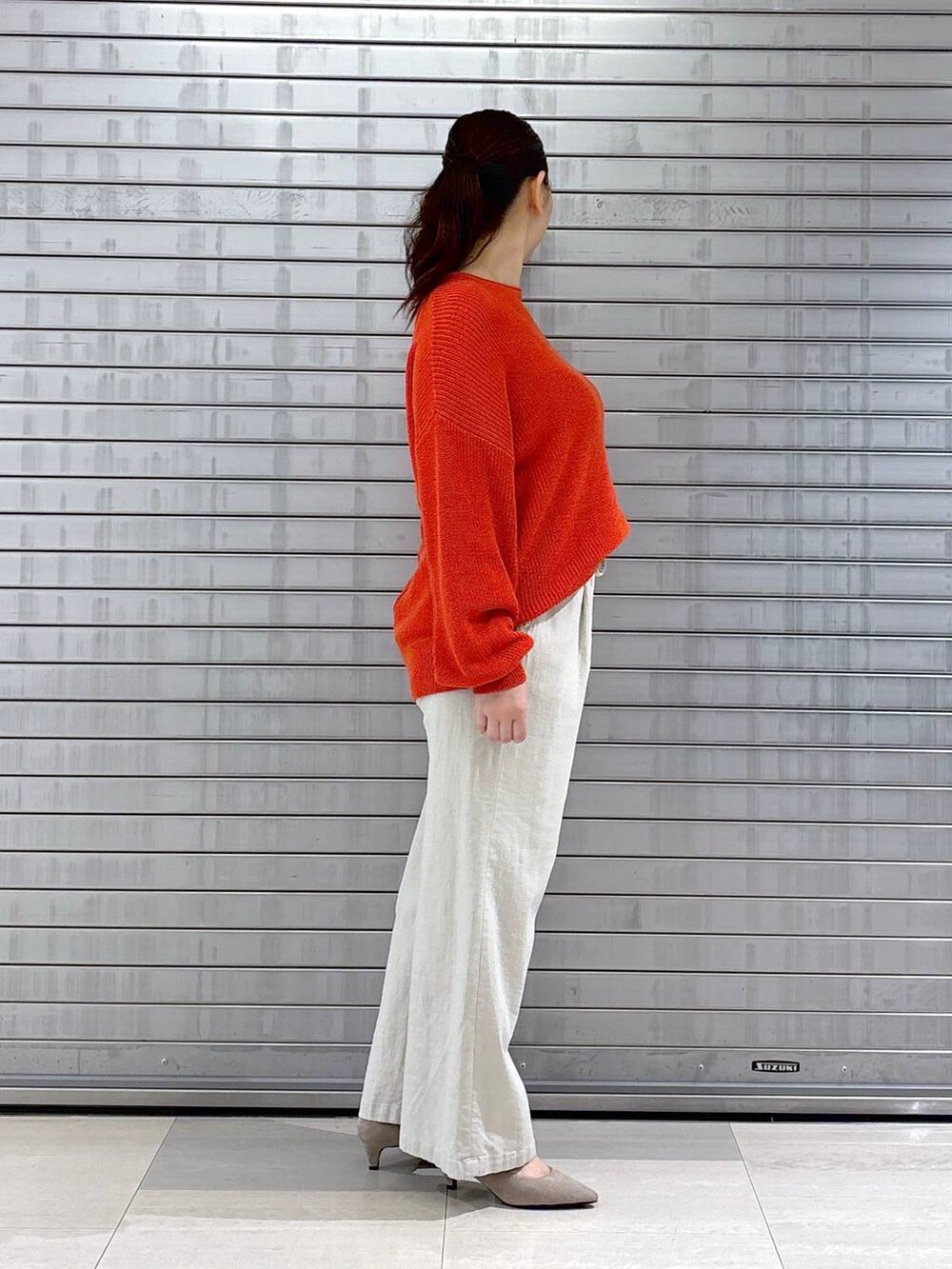 ベージュ系のパンプス、オレンジ系のニット/セーター、ベージュ系のその他パンツを着用したレディースの春コーディネートの5枚目の写真